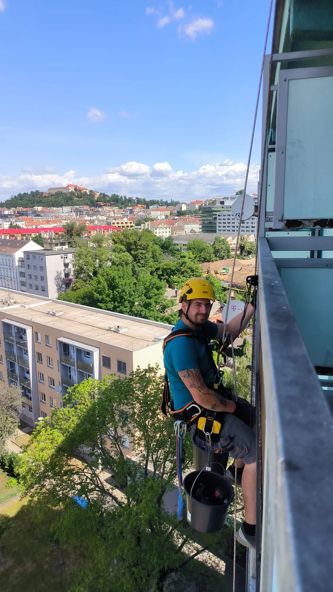 Výškový pracovník na laně při práci na budově